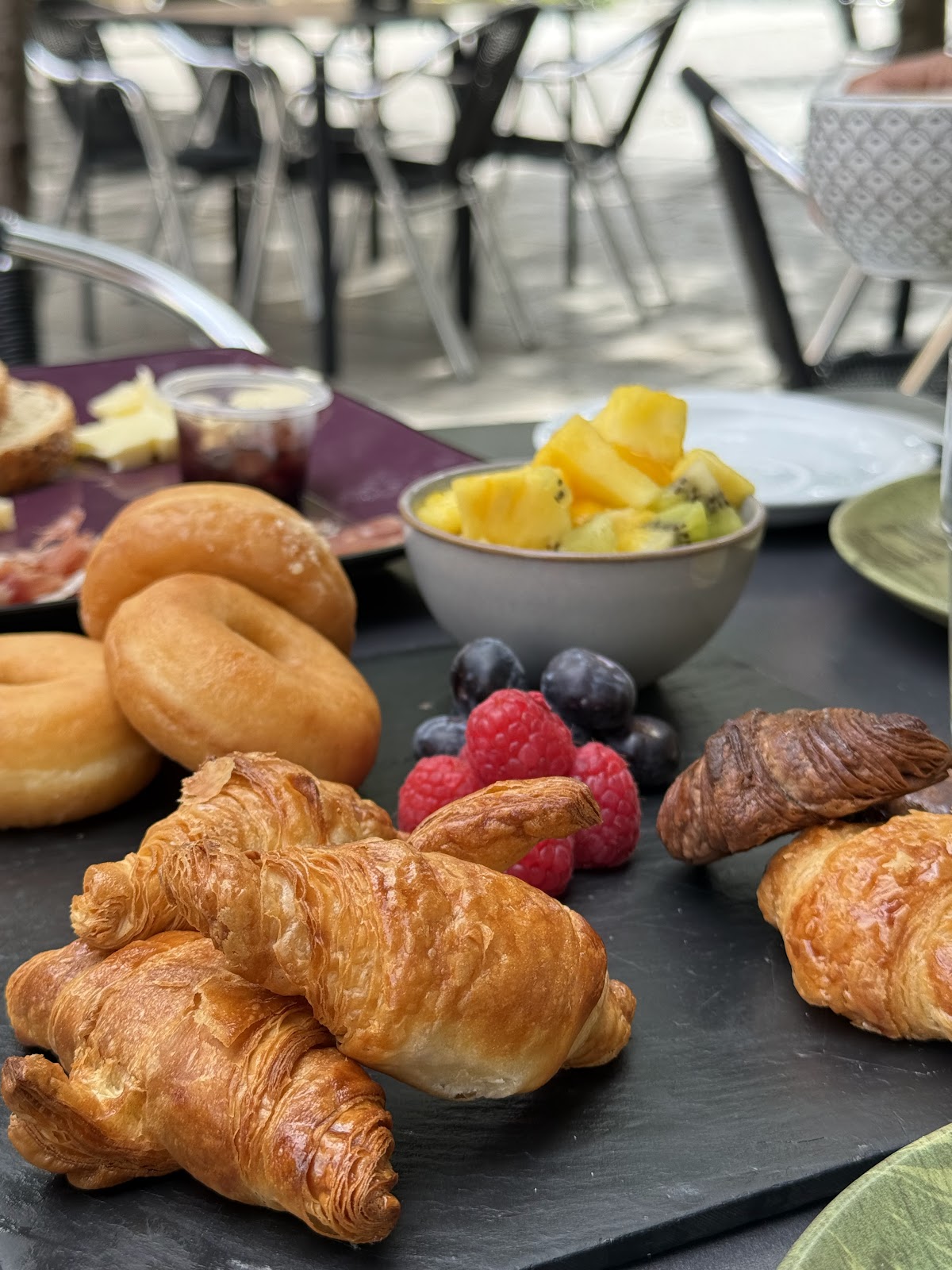 Desayuno variado con croissants, donas y frutas frescas